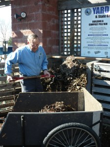 Turning the compost Turning the compost into a wheelbarrow so it can be mixed and forked back into the bin.